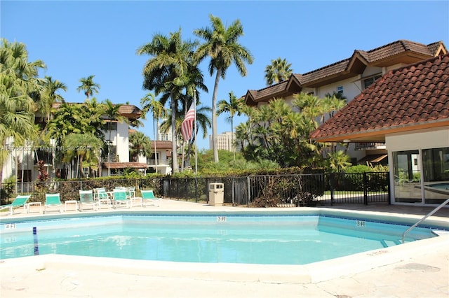 pool with a patio and fence