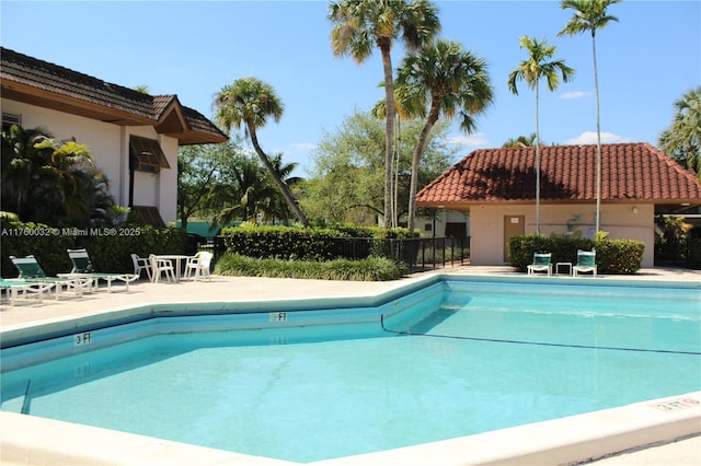 community pool featuring a patio area and fence