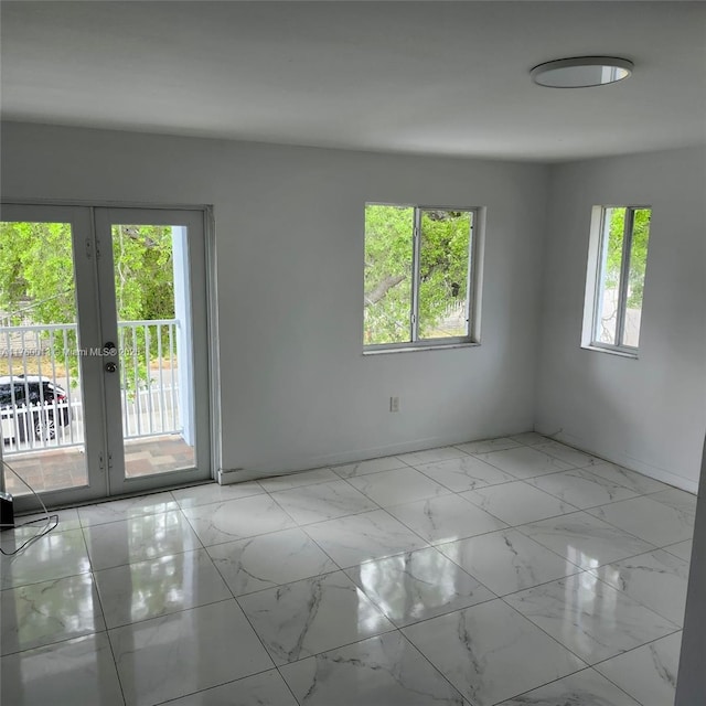 empty room featuring french doors and marble finish floor