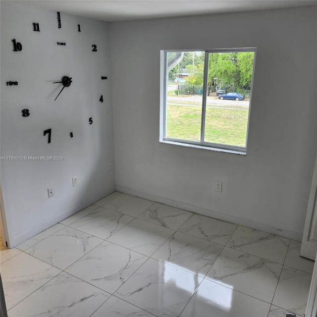 unfurnished room with baseboards and marble finish floor