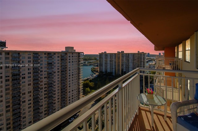 balcony featuring a water view and a city view