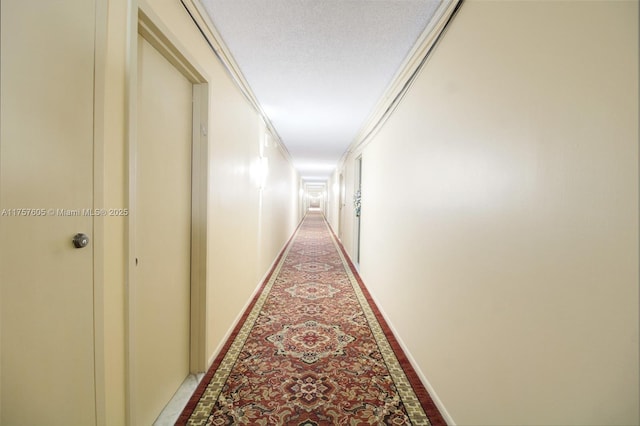 hallway with ornamental molding and baseboards