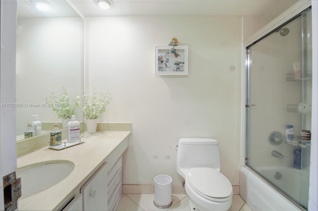 bathroom with tile patterned floors, toilet, vanity, and bath / shower combo with glass door