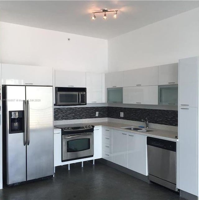 kitchen featuring white cabinets, appliances with stainless steel finishes, light countertops, and a sink