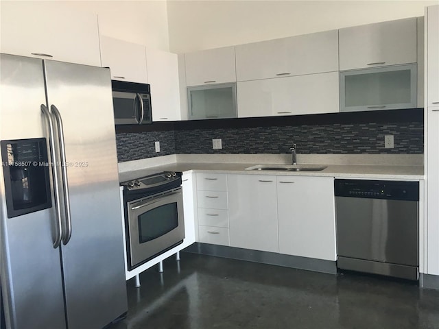 kitchen featuring backsplash, finished concrete floors, light countertops, appliances with stainless steel finishes, and a sink