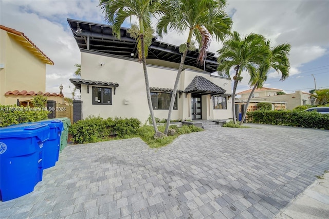 mediterranean / spanish-style house featuring a tile roof and stucco siding