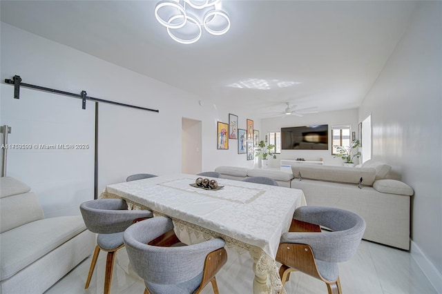 dining room with light tile patterned floors, ceiling fan, and a barn door