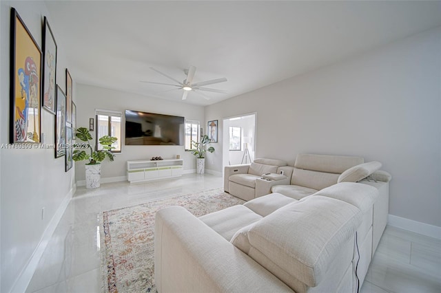 living room with baseboards and ceiling fan