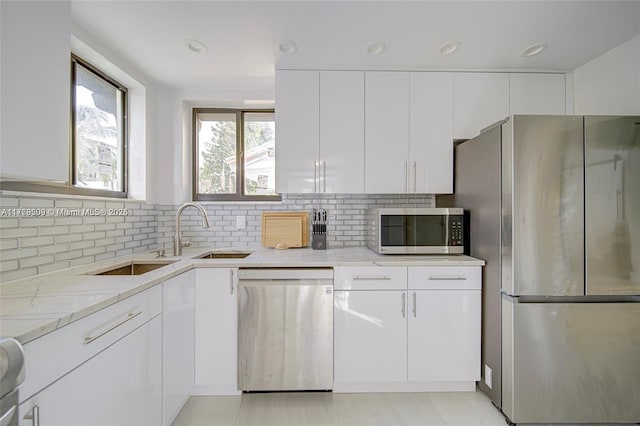 kitchen with white cabinetry, recessed lighting, appliances with stainless steel finishes, decorative backsplash, and light stone countertops