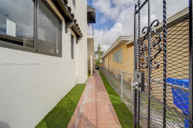 view of home's exterior with stucco siding and fence