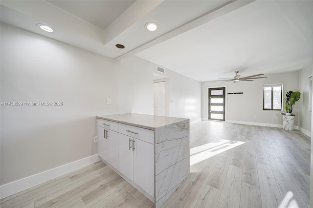 kitchen featuring visible vents, baseboards, a peninsula, and light wood finished floors