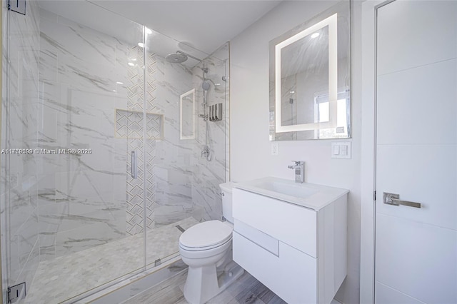 bathroom with vanity, toilet, and a shower stall