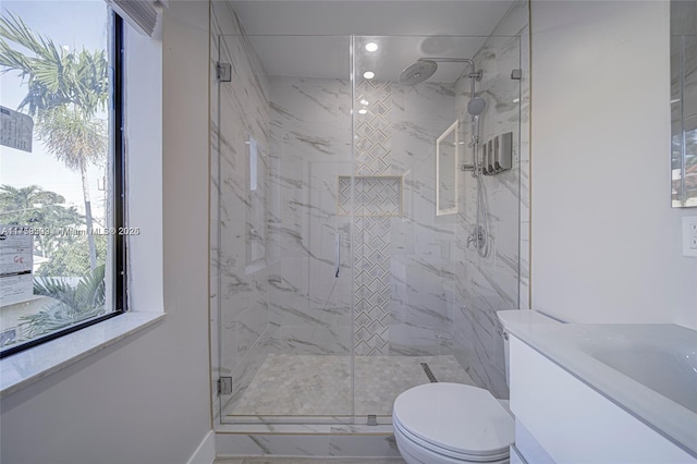 bathroom with a marble finish shower, plenty of natural light, marble finish floor, and toilet