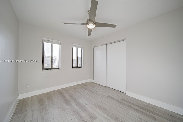 unfurnished bedroom featuring a closet, baseboards, and light wood finished floors