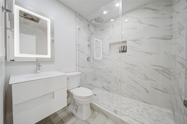 full bath featuring a marble finish shower, toilet, and vanity