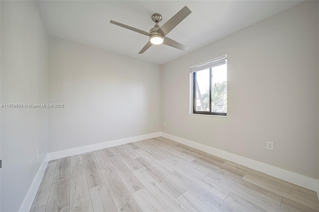 spare room with light wood-type flooring, baseboards, and a ceiling fan