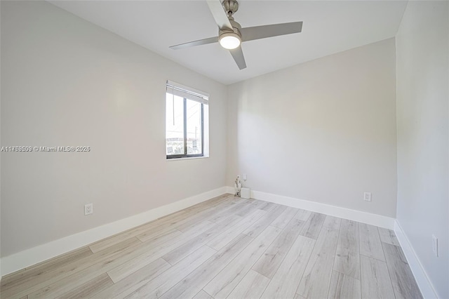 empty room with a ceiling fan, light wood-style floors, and baseboards