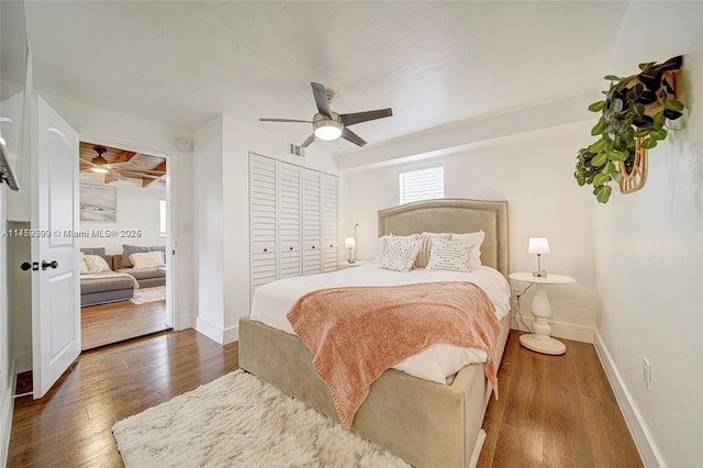 bedroom with a closet, a ceiling fan, baseboards, and wood finished floors