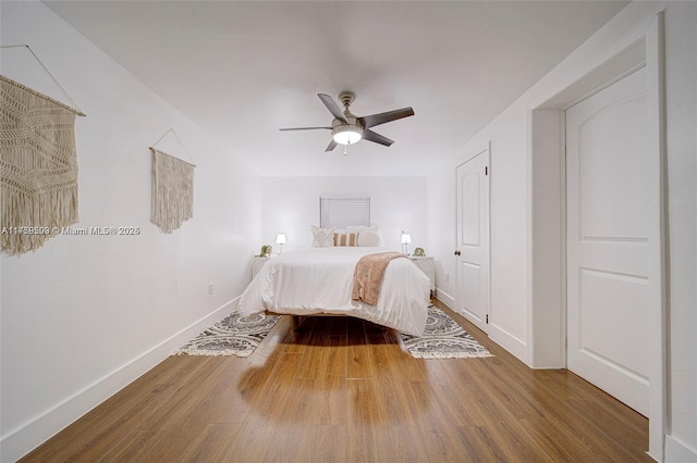 bedroom with wood finished floors, baseboards, and ceiling fan