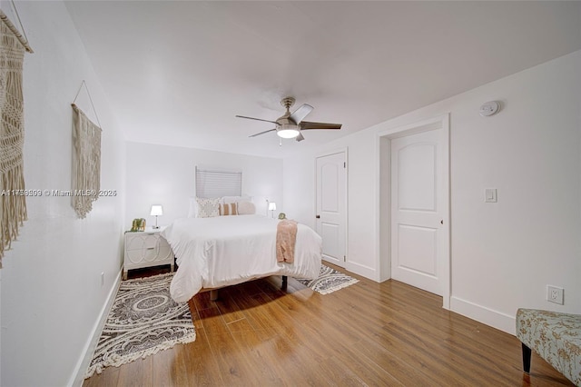 bedroom featuring wood finished floors, baseboards, and ceiling fan