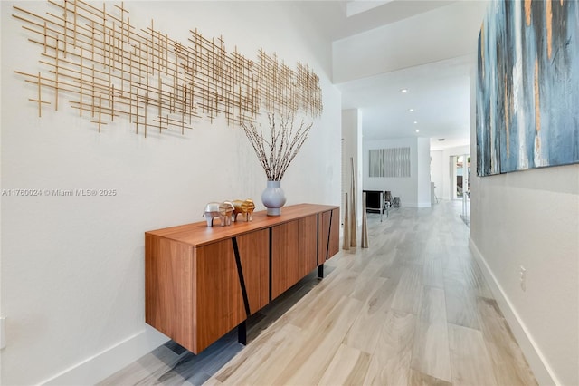 hall featuring baseboards and light wood-style flooring