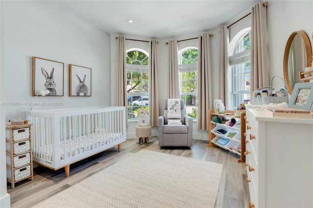 bedroom featuring a crib and wood finished floors