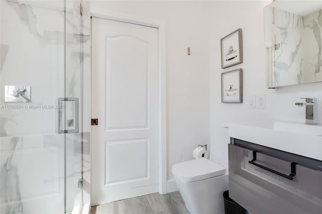 full bathroom featuring a marble finish shower, toilet, and vanity
