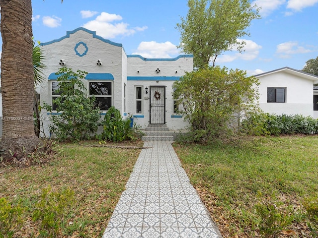 view of front of home with stucco siding and a front lawn