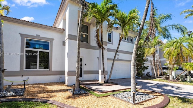 view of home's exterior with stucco siding, an attached garage, and driveway