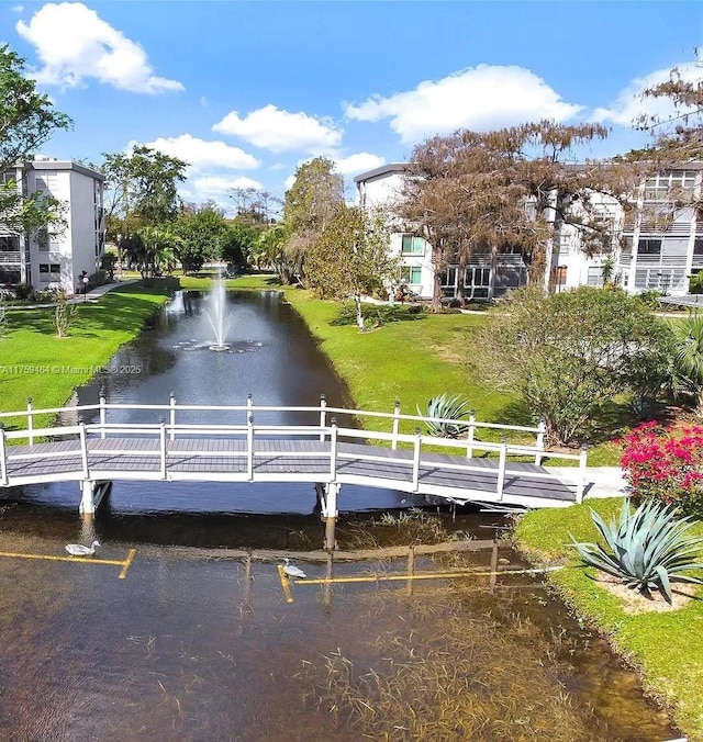 view of community with a water view and a lawn