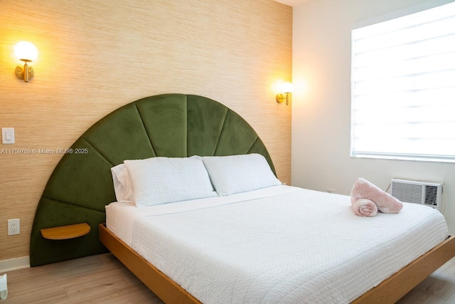 bedroom featuring visible vents, baseboards, and wood finished floors