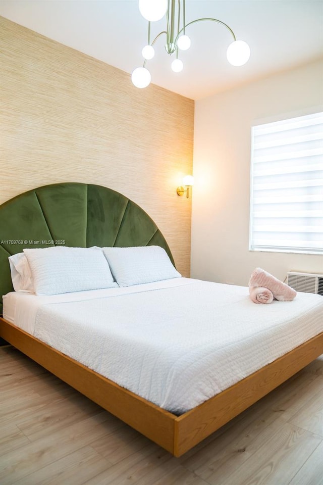 bedroom featuring a notable chandelier, wood finished floors, and visible vents