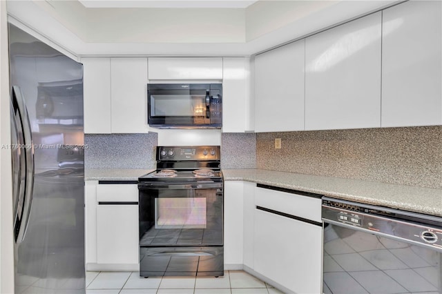 kitchen with tasteful backsplash, white cabinets, black appliances, and modern cabinets