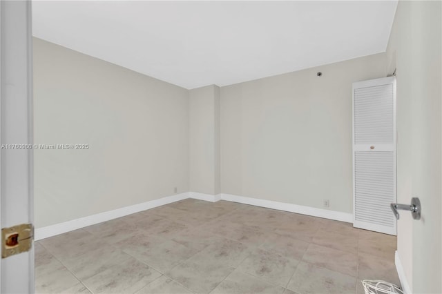 unfurnished room with baseboards