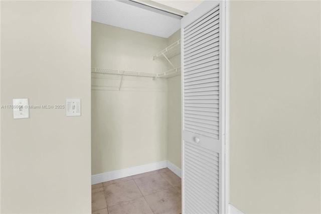 walk in closet with light tile patterned floors