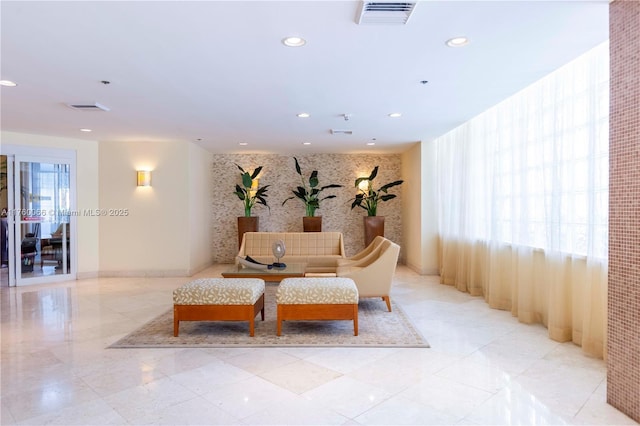 interior space featuring visible vents, recessed lighting, an accent wall, and baseboards