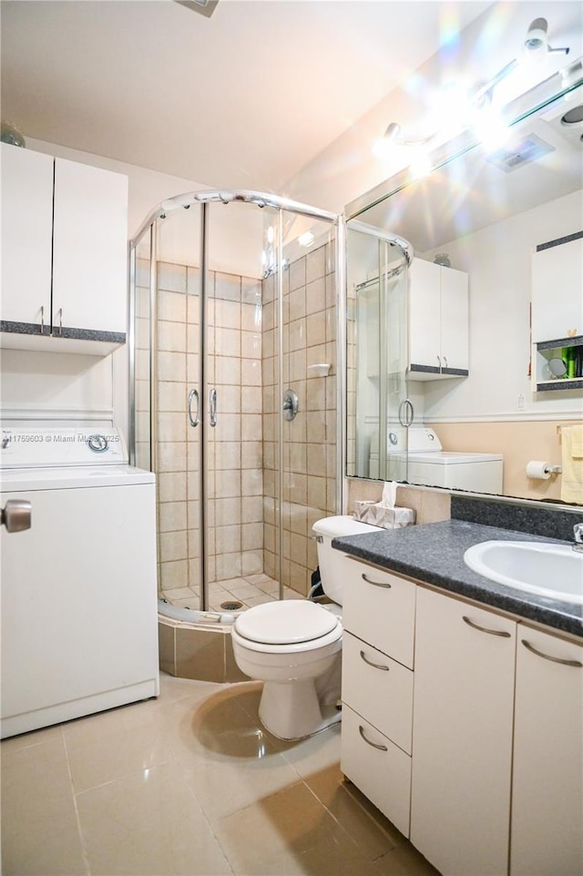 bathroom with vanity, separate washer and dryer, a stall shower, tile patterned flooring, and toilet