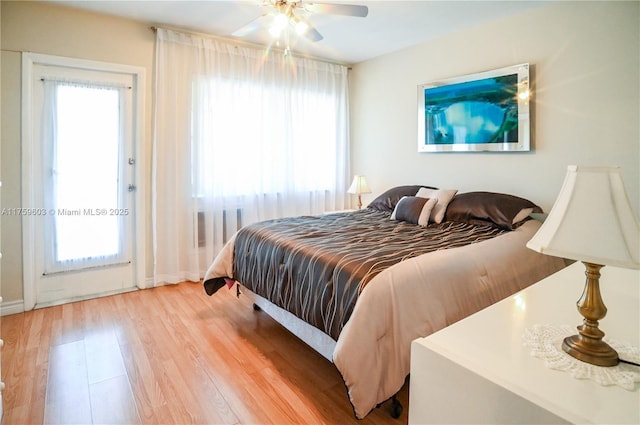 bedroom featuring multiple windows, ceiling fan, and wood finished floors