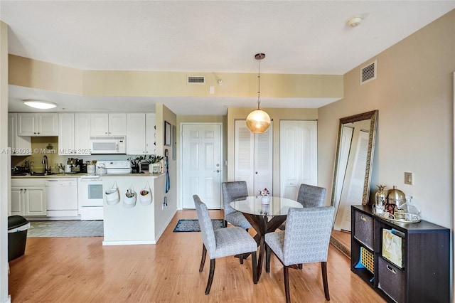 dining room featuring light wood-type flooring and visible vents