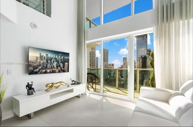 living room with concrete flooring and a towering ceiling