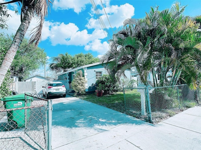 view of front facade featuring a fenced front yard, concrete driveway, and a gate