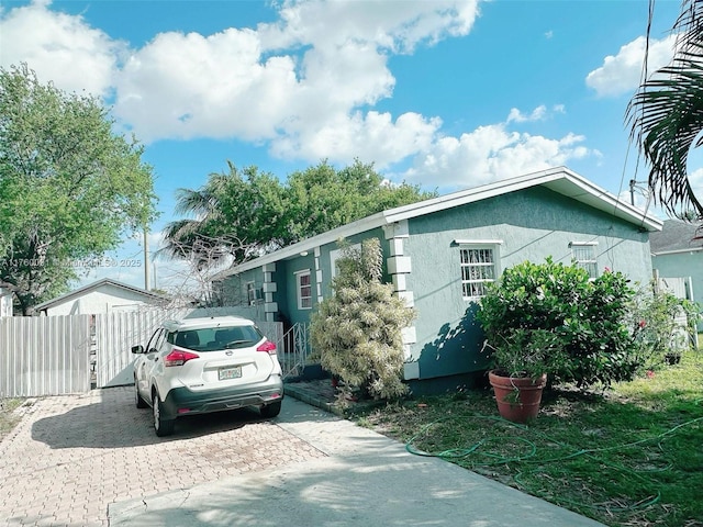 view of front of property featuring stucco siding and fence