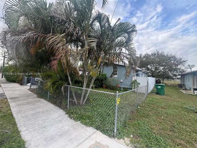 view of side of home featuring a fenced front yard and a yard