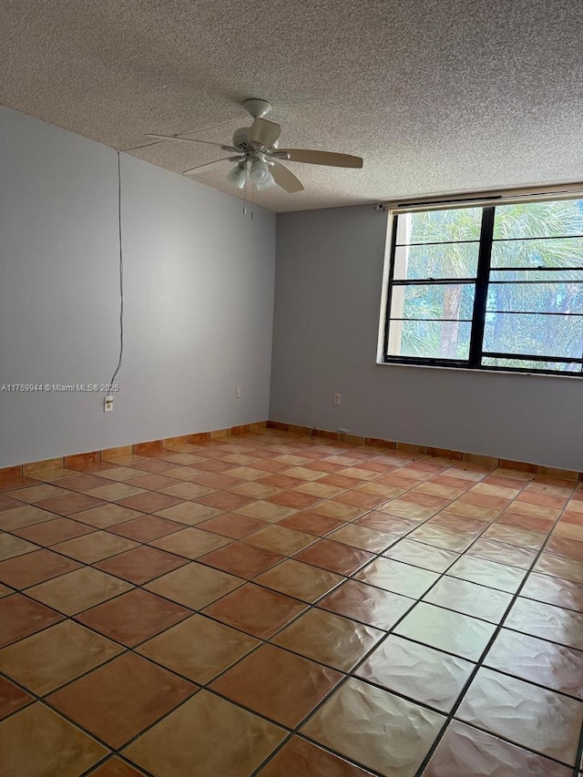 unfurnished room with light tile patterned floors, baseboards, a textured ceiling, and ceiling fan