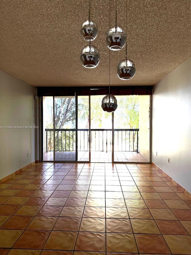 spare room with tile patterned flooring and a textured ceiling