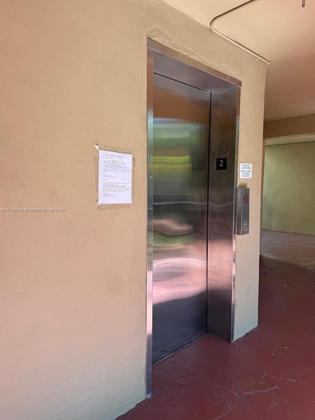 room details with elevator and finished concrete flooring