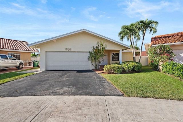 view of front of property featuring a front lawn, fence, driveway, and stucco siding