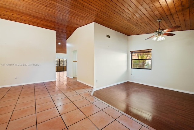 unfurnished room with baseboards, light tile patterned floors, wood ceiling, and a ceiling fan