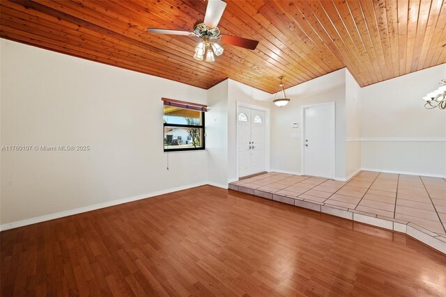 foyer entrance featuring baseboards, wood ceiling, and vaulted ceiling