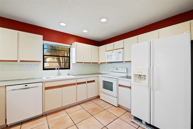 kitchen with white appliances, light tile patterned floors, light countertops, and a sink